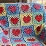 Manta em granny square de coração em crochê para aquecer com carinho