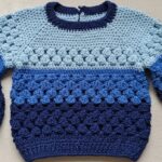 Suéter infantil em tons de azul em crochê que aquece com estilo e amor