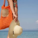 Bolsa em crochê estilo praia com base firme e fecho de botão que une leveza e praticidade