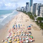 Adeus tomadas, conheça a sombrinha solar que carrega celular e resfria bebidas na praia