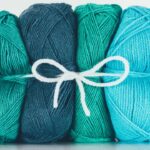 Almofada de crochê turquesa com mistura de pontos e cores vibrantes