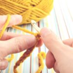 Cropped de crochê amarelo mostarda com correntinhas duplas e caimento leve