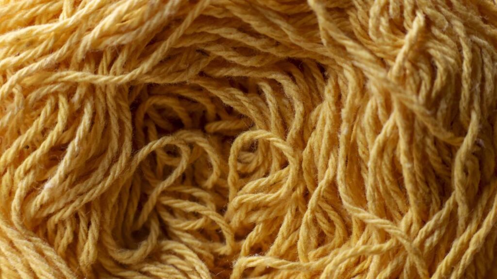 Cropped de crochê amarelo mostarda com correntinhas duplas e caimento leve