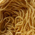 Cropped de crochê amarelo mostarda com correntinhas duplas e caimento leve