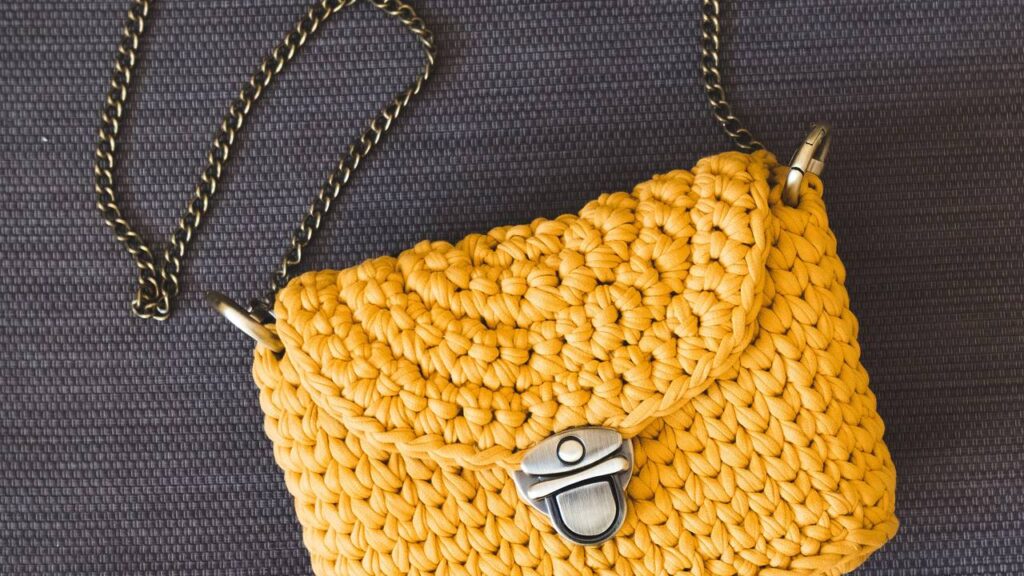 Bolsa clutch de crochê com fecho metálico e ponto concha para um toque sofisticado